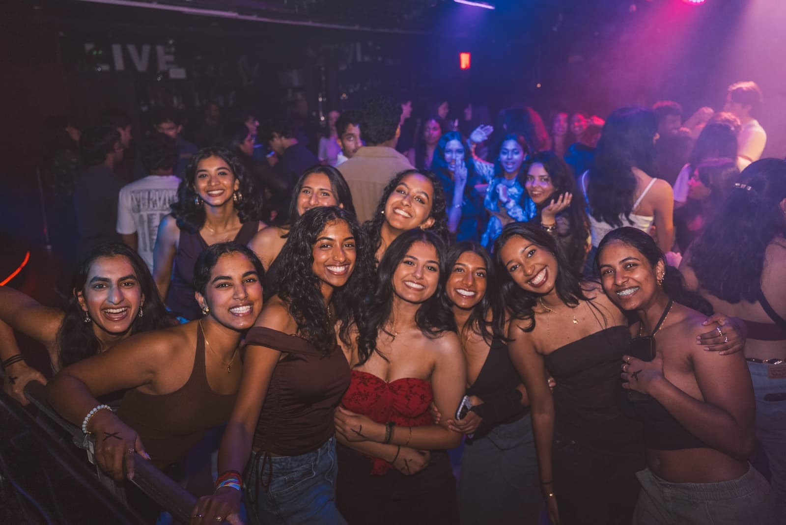 Students smiling together on a packed dance floor