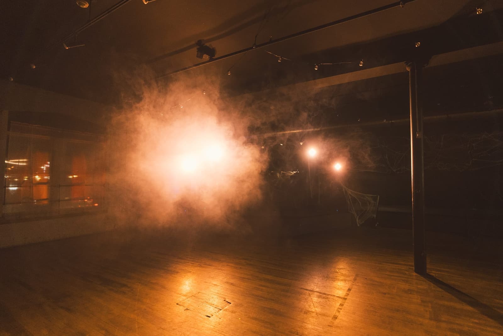 An event room transformed with warm amber lighting and haze