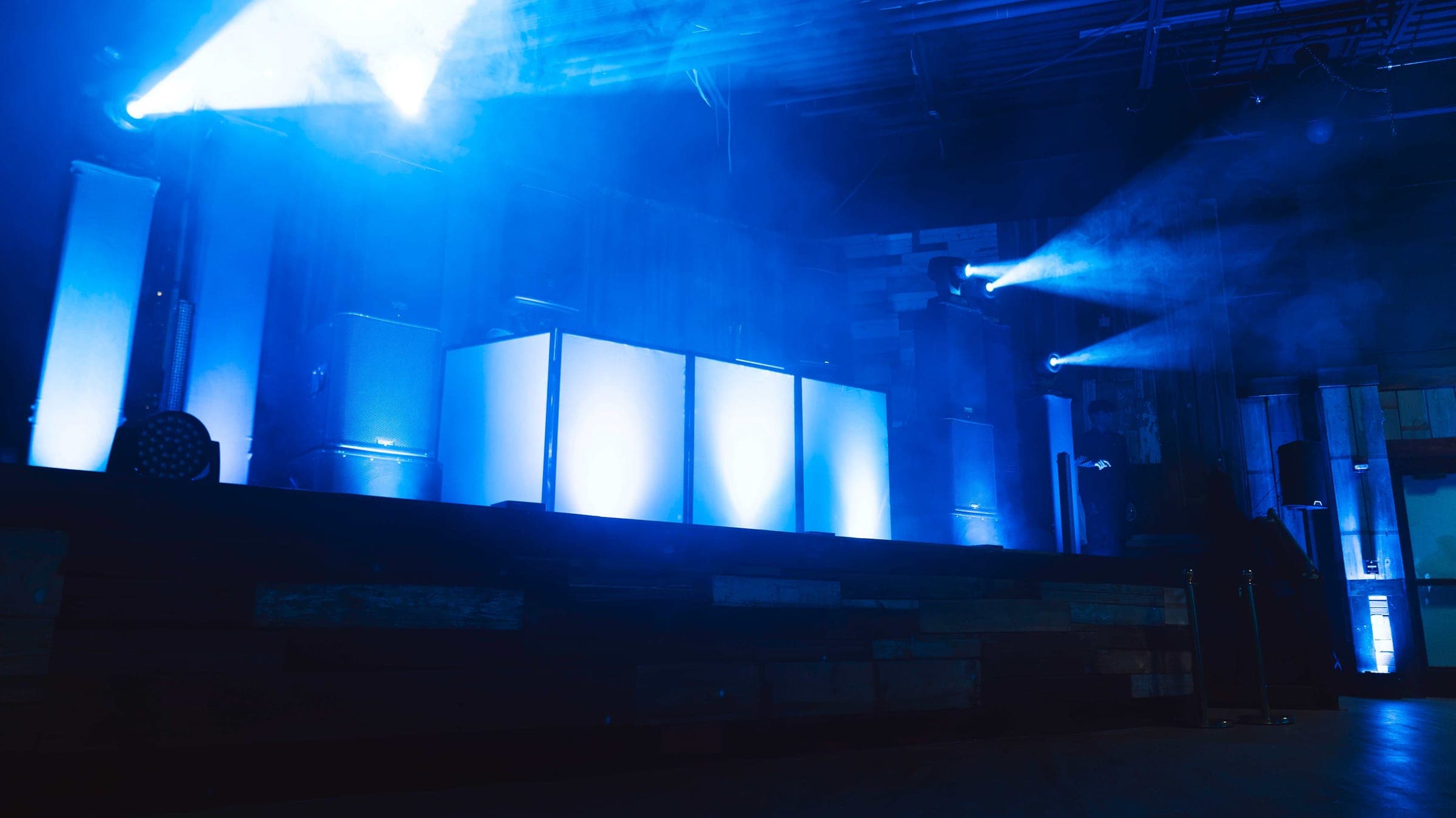 Bright blue moving beams cutting through atmospheric haze
