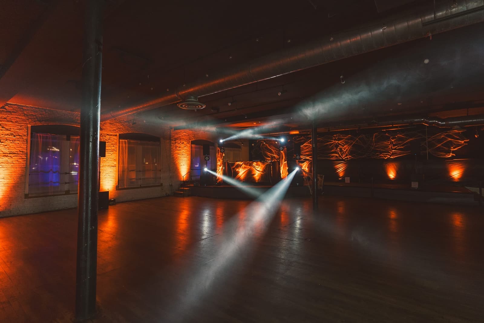 Moving beams and uplighting transforming an industrial event venue