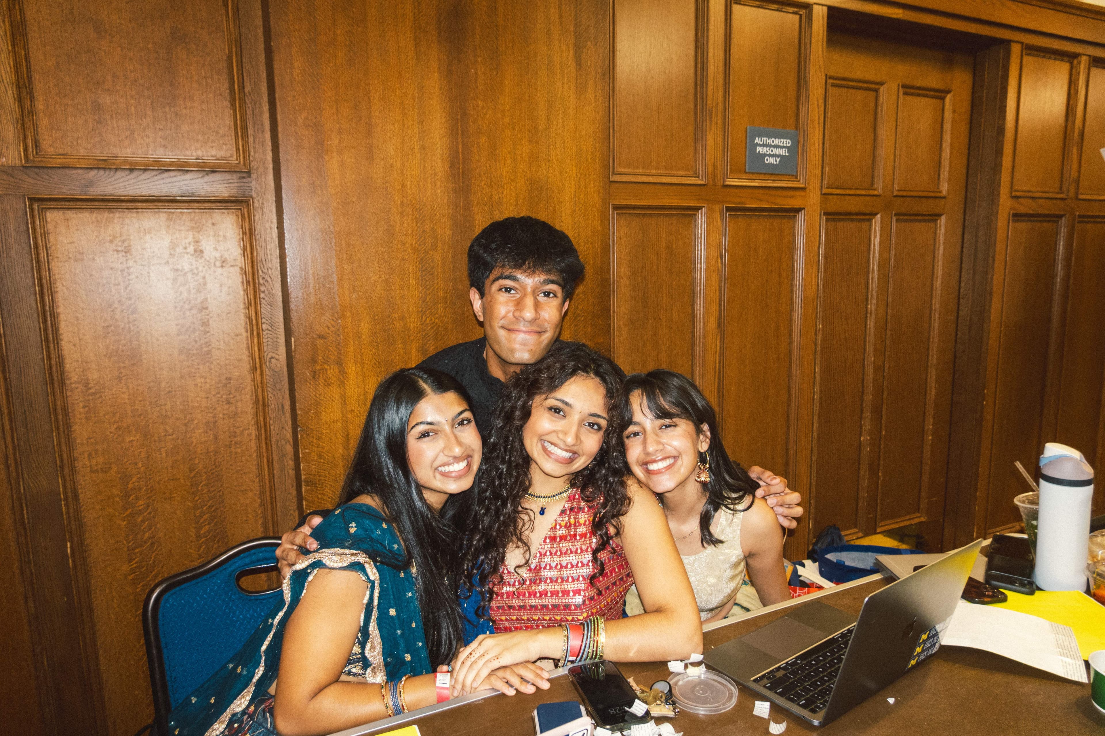 Four friends smiling together at the check-in table
