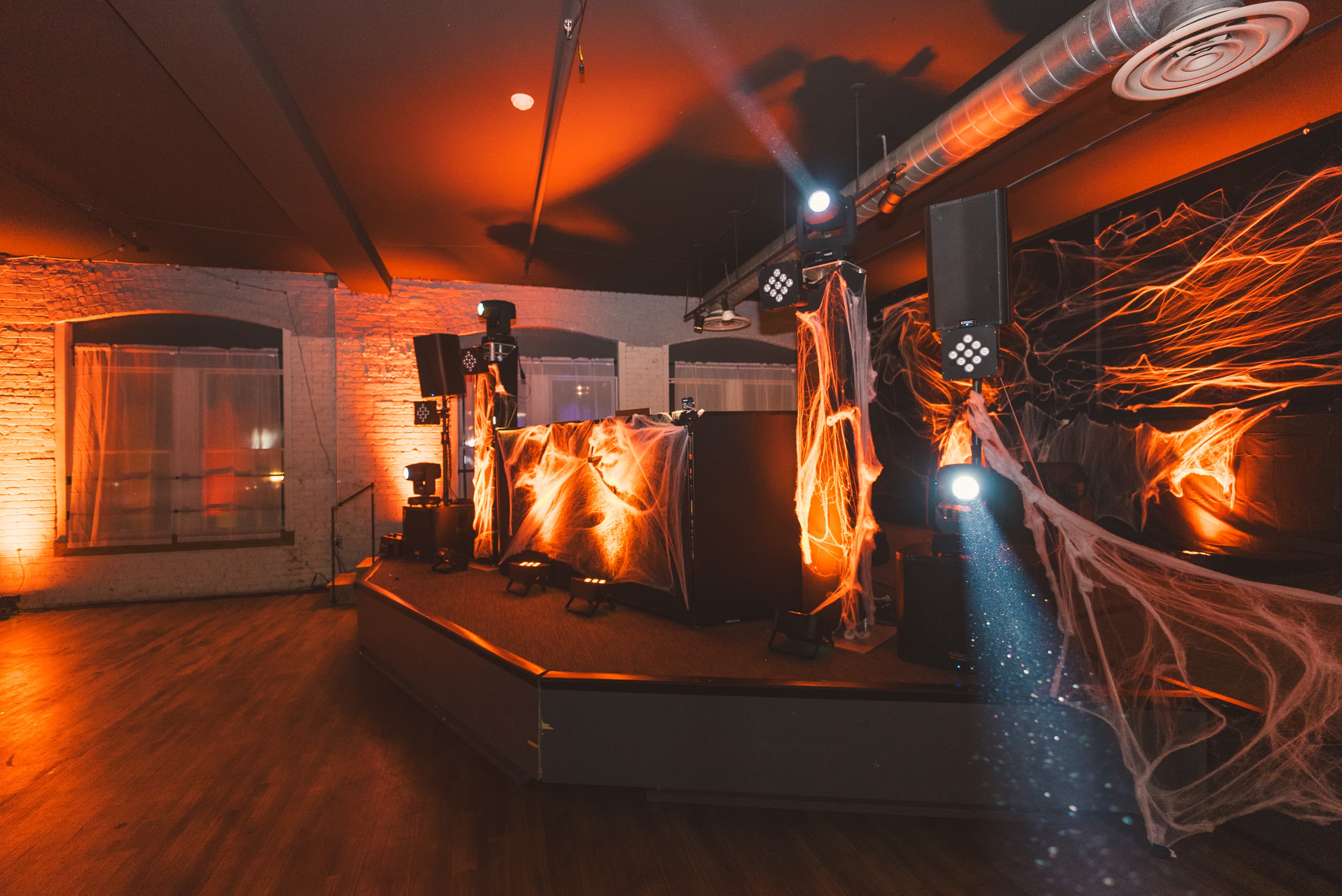 The stage and DJ booth wrapped in glowing orange cobwebs