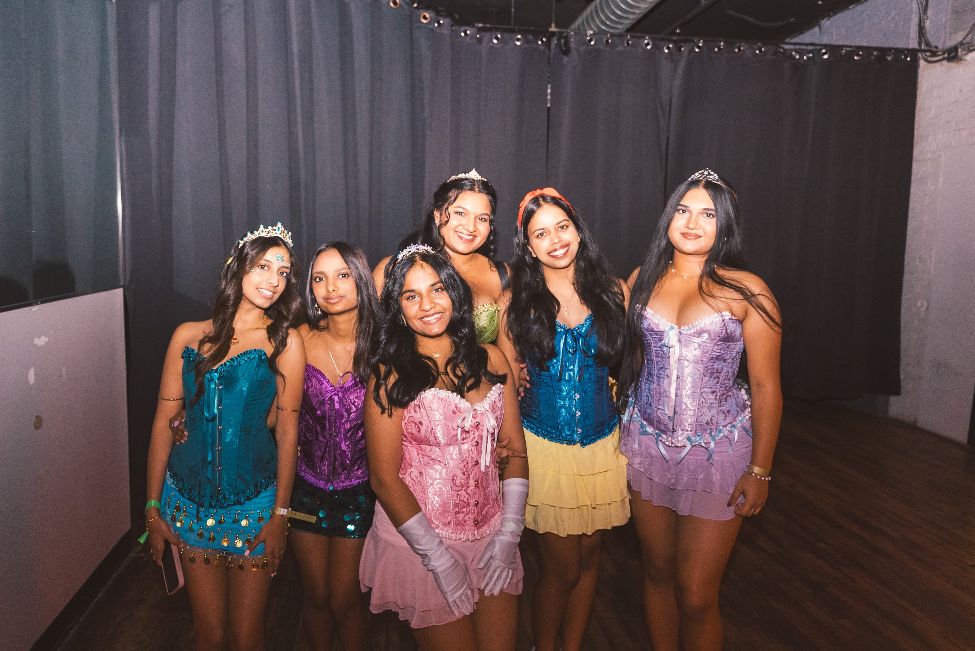 Six friends in colorful corset princess costumes and tiaras