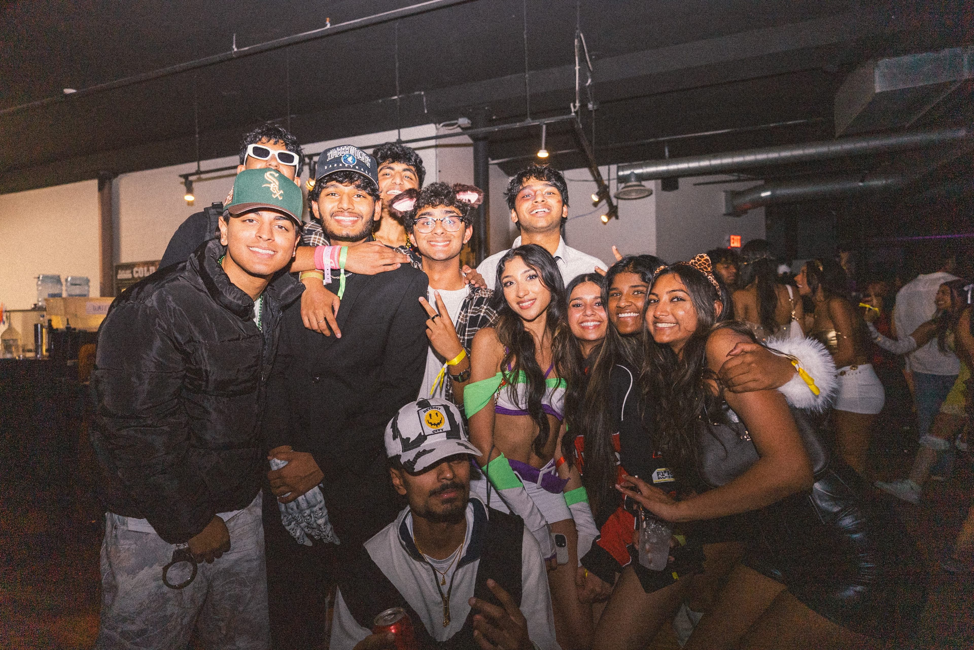 A large group of friends in costumes crowding in for a photo
